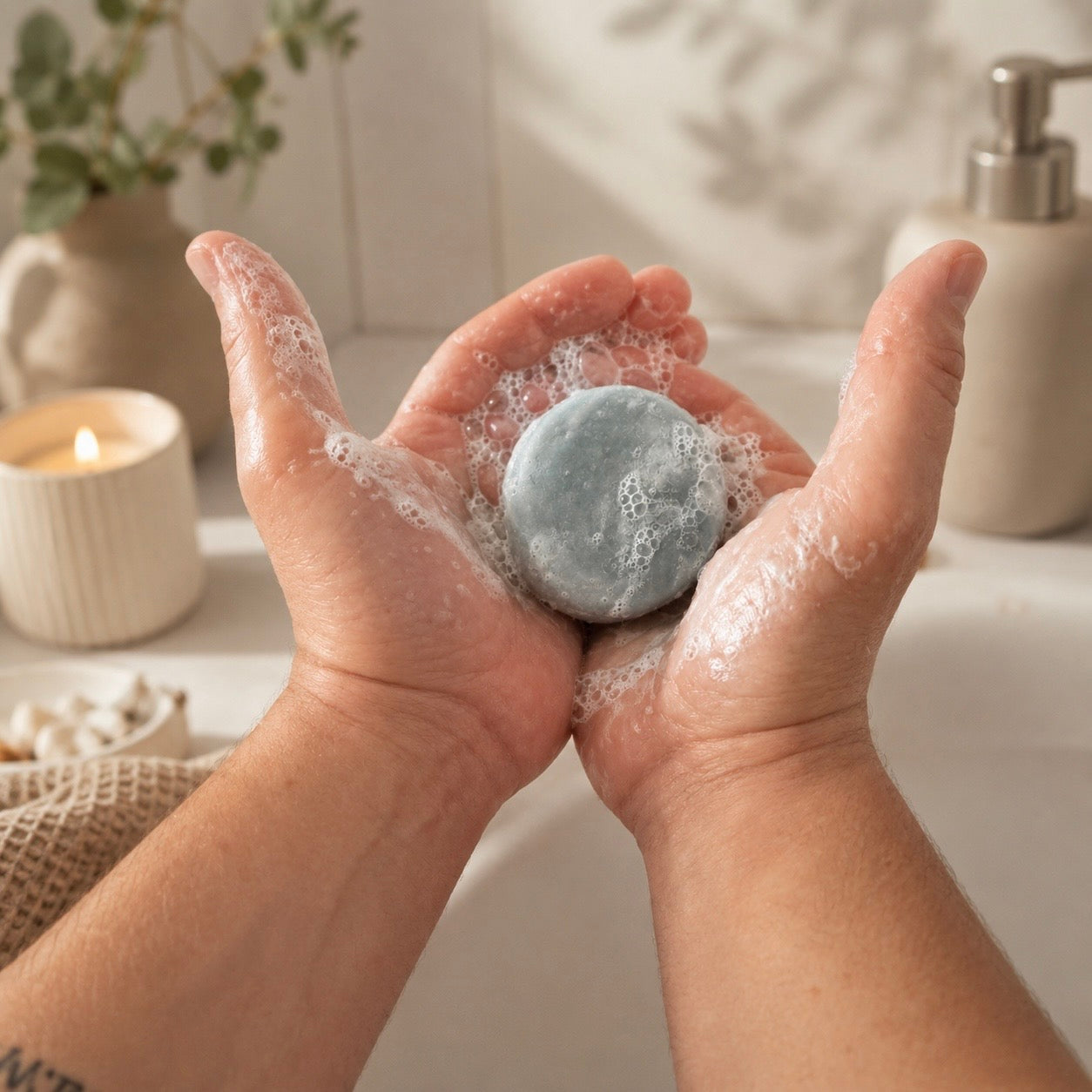 Hände mit eingeschäumter trojbaltyk Shampoo Bar Nordklar Brise im Badezimmer
